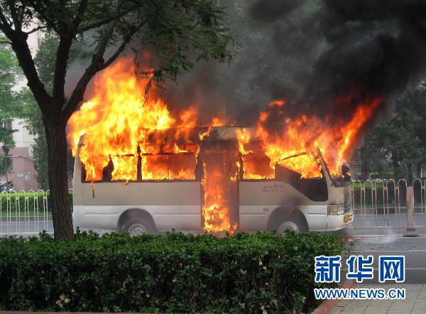 A minivan catches fire on Monday afternoon on Xuanwumen West Street, Beijing, when it self-ignited. As temperatures remain high in the city, overworked car engines can burst into flames. [Xinhua] 