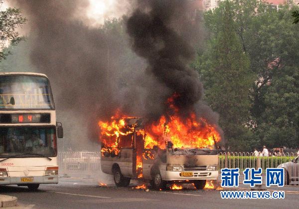 A minivan burns after it self-ignited on Xuanwumen West Street, Beijing on June 28, 2010.[Xinhua]