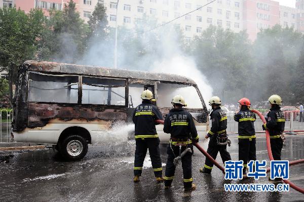 Firefighters put out a minivan fire on Xuanwumen West Street, Beijing on June 28, 2010. [Xinhua]