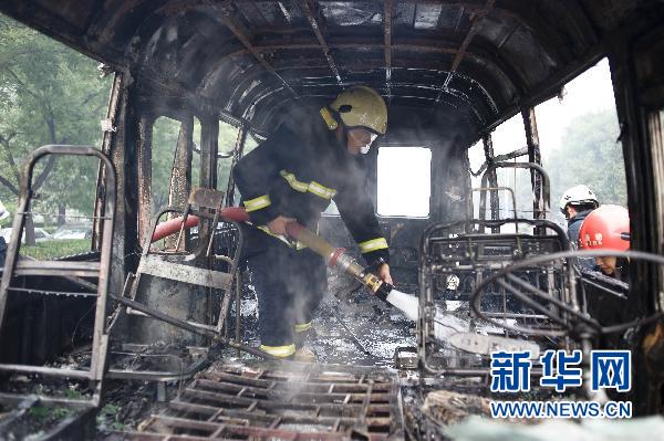 Firefighters put out the fire inside a minivan on Xuanwumen West Street, Beijing on June 28, 2010.[Xinhua]