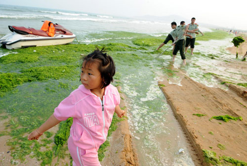 A girl walks through the cleanup site in Qingdao, Shandong province, June 27, 2010. [Xinhua]