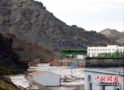 A view of a flooded school and flood victims evacuated to safety on a hill in Qitai County, Northwest China&apos;s Xinjiang Uygur autonomous region. [Chinanews.com]