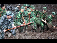 Rescuers clean up debris from a rain-triggered landslide that on Monday afternoon buried about 107 people, in Dazhai village of Guanling County, Southwest China's Guizhou province, on Tuesday June 29, 2010. [Xinhua]