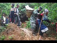 A soldier evacuates villagers affected by a rain-triggered landslide that on Monday afternoon buried about 107 people in Dazhai village of Guanling County, Southwest China's Guizhou province, on Tuesday June 29, 2010. [Xinhua]