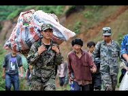 Soldier evacuate villagers affected by a rain-triggered landslide that on Monday afternoon buried about 107 people in Dazhai village of Guanling County, Southwest China's Guizhou province, on Tuesday June 29, 2010. [Xinhua]