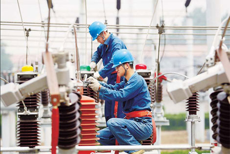 Workers carry out maintenance work at a power installation in Anhui province.[China Daily]