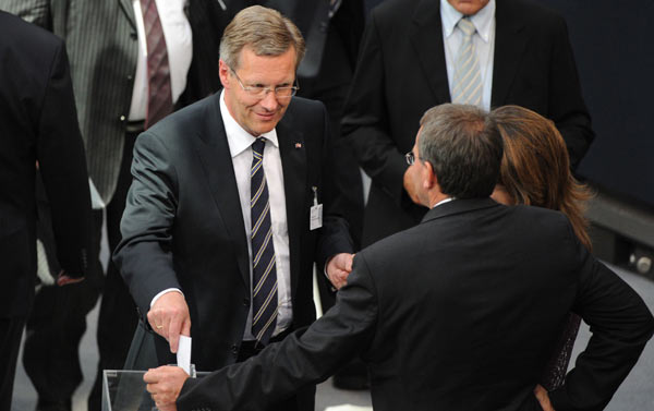Christian Wulff, presidential candidate of the ruling German coalition, center, casts his ballot for the election of the German President during the Federal Assembly in the Berlin Reichstag parliament building, Wednesday, June 30, 2010.[Xinhua/AFP]