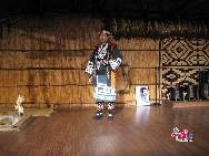 An Ainu man in ethnic dress is performing in the Ainu Museum in north Japan's Hokkaido.[Photo by Chen Huang]