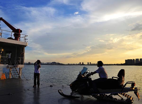 A crew member takes picutres of another on the deck of the icebreaker Xuelong, or 'Snow Dragon', the carrier for China's fourth scientific Arctic expedition, in Xiamen, southeast China's Fujian Province, on June 30, 2010. The Xuelong will set out on July 1.