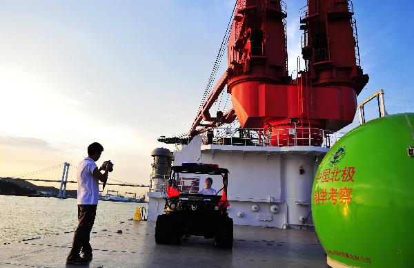 A crew member takes picutres of another on the deck of the icebreaker Xuelong, or 'Snow Dragon', the carrier for China's fourth scientific Arctic expedition, in Xiamen, southeast China's Fujian Province, on June 30, 2010. The Xuelong will set out on July 1.