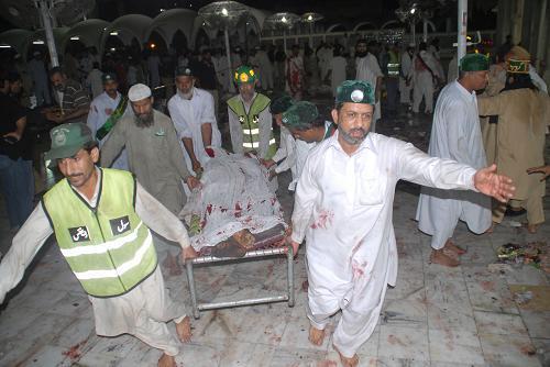 Rescuers carry a victim from the blast site in eastern Pakistani city of Lahore on July 2, 2010. At least 43 people were killed and 175 others injured in three suicide bomb attacks at a shrine in Lahore late Thursday night, according to local sources and media reports. [Jamil Ahmad/Xinhua] 