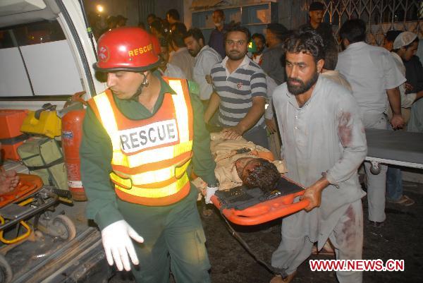 Rescuers carry a body out of the blast site in eastern Pakistani city of Lahore on July 2, 2010. At least 43 people were killed and 175 others injured in three suicide bomb attacks at a shrine in Lahore late Thursday night, according to local sources and media reports. [Jamil Ahmad/Xinhua] 