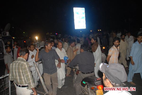 People gather around the blast site in eastern Pakistani city of Lahore on July 2, 2010. At least 43 people were killed and 175 others injured in three suicide bomb attacks at a shrine in Lahore late Thursday night, according to local sources and media reports.[Jamil Ahmad/Xinhua] 