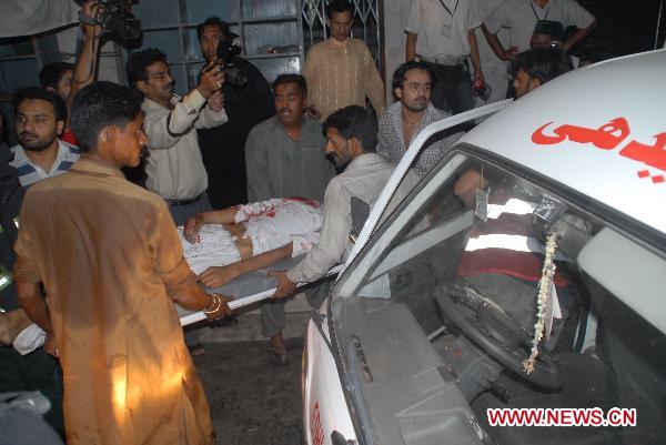 Rescuers carry a body onto a truck at the blast site in eastern Pakistani city of Lahore on July 2, 2010. At least 43 people were killed and 175 others injured in three suicide bomb attacks at a shrine in Lahore late Thursday night, according to local sources and media reports. [Jamil Ahmad/Xinhua] 