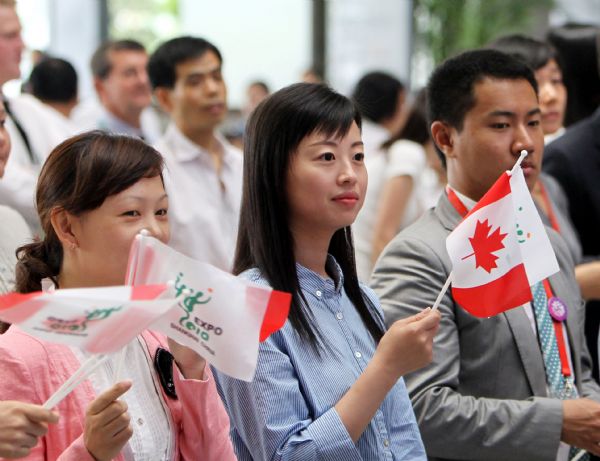 Audiences wave national flags of Canada during a ceremony marking the Canada National Pavilion Day at the Shanghai World Expo in Shanghai, east China, July 1, 2010. 