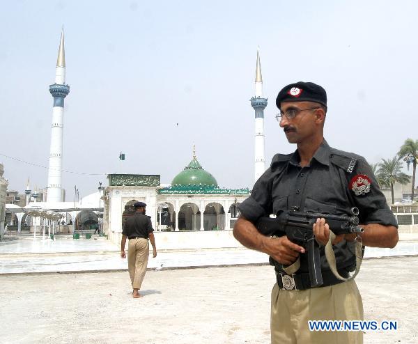 A policeman guards outside the blast site in eastern Pakistani city of Lahore on July 2, 2010. At least 43 people were killed and 175 others injured in three suicide bomb attacks at a shrine in Lahore late Thursday night. [Jamil Ahmad/Xinhua]