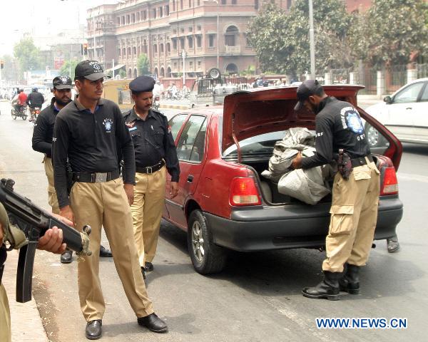 Police guards check a car near the blast site in eastern Pakistani city of Lahore on July 2, 2010. [Jamil Ahmad/Xinhua]