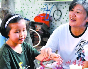A daughter with visual impairment plays with a woman who comes to help the family. [Photo/Guangzhou Daily]