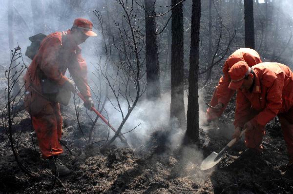 Firefighters extinguish fire in the Greater Hinggan Mountains of northeast China's Heilongjiang Province, July 2, 2010. 