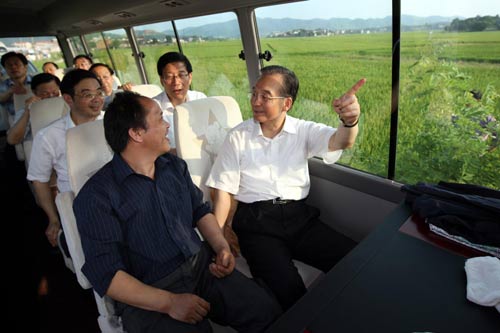 Chinese Premier Wen Jiabao (R) talks to a local farmer during his visit to fllod-hit Ningxiang county, in Central China's Hunan Province, July 1, 2010. [Photo/Xinhua] 