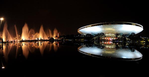 Photo taken on July 2, 2010 shows visitors stroll in the illuminating World Expo Park in Shanghai, east China. More and more people prefer the night hiking in the World Expo Park to the daytime in order to avoid heat and crowded visitors. [Xinhua/Yan Yan]