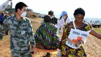 Chinese peacekeeping medics help a local Red Cross worker transit a man injured in the oil tanker explosion at the airport in Bukavu, Sud-Kivu, in the Democratic Republic of Congo.