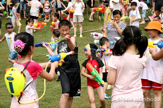 Children splash water on each other with water guns in Nanjing in East China&apos;s Jiangsu province, July 4, 2010. [China Daily/Asianewsphoto]