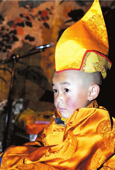 Four-year-old Losang Doje dons ceremonial robes on Sunday following his selection as the 6th Living Buddha Dezhub, when a lot-drawing ceremony in the Jokhang Temple in Lhasa, capital of the Tibet autonomous region, singled him out as the reincarnation of the 5th Living Buddha Dezhub. [Xinhua]