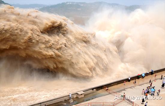 Spectators watch the desilting process at Xiaolangdi Reservoir on the Yellow River on July 4, 2010. [China Daily/Asianewsphoto] 