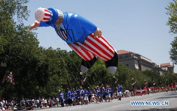 People fly an inflatable toy during the Independence Day parade in Washington D.C., capital of the United States, July 4, 2010. The United States celebrated its 234th Independence Day on Sunday. [Zhang Jun/Xinhua]