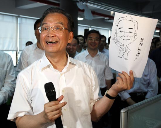 Premier Wen Jiabao receives a cartoon of himself as a gift during a visit to Talkweb Information System Co Ltd in Hunan's provincial capital Changsha, July 2, 2010. [Xinhua]