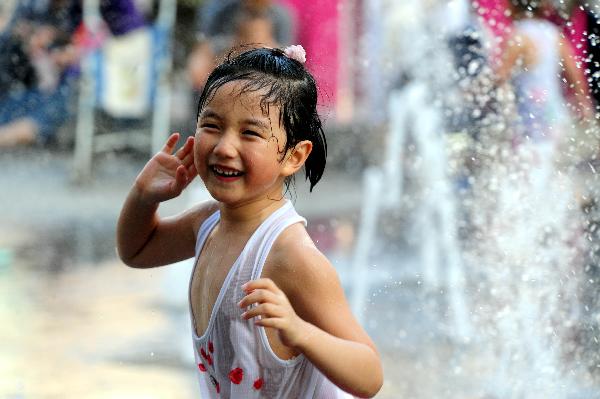A girl plays at a fountain in Shenyang, capital of northeast China's Liaoning Province, on July 3, 2010. Hot weather swept most regions in northern, central and southern China these days, with temperature of some regions soaring to 39 degrees celsius. [Xinhua]