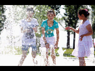 Three girls play at a fountain to enjoy coolness at the Tianjin University in north China's Tianjin Municipality, July 5, 2010. The local meteorologic authority has issued an orange alarm against high temperature.[Xinhua]