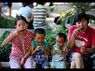 People eat popsicles in Nanning, capital of southwest China's Guangxi Zhuang Autonomous Region, July 5, 2010. Chinese meteorological authority said Monday hot weather continues to scorch many parts of the country. The highest temperature of Guangxi reached 39.5 degrees Celsius on Monday.[Xinhua]