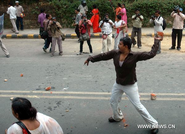 A protestor throws bricks to policemen in Lucknow, capital of Indian state of Uttar Pradesh, on July 5, 2010. Parts of India Monday got paralyzed by a daylong nationwide strike called out by opposition political parties against the recent hike of fuel prices and the spiraling prices of essential commodities. [Stringer/Xinhua]