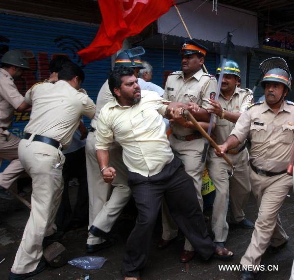 Policemen try to stop protestors at Andheri Railway Station in Mumbai, India, on July 5, 2010. Parts of India Monday got paralyzed by a daylong nationwide strike called out by opposition political parties against the recent hike of fuel prices and the spiraling prices of essential commodities. [Prakash Deshmukhr/Xinhua]