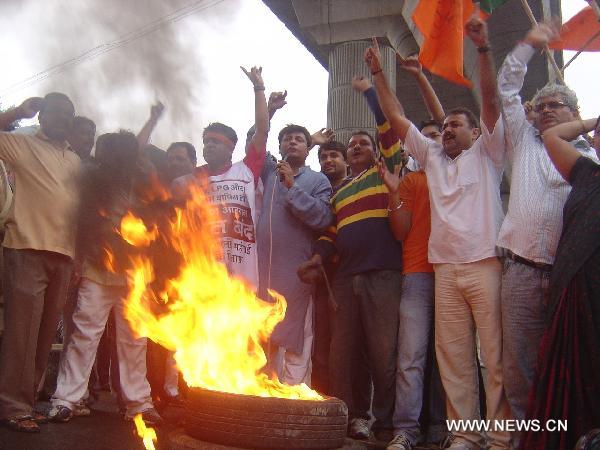 Protestors burn tyres in New Dehli, capital of India, on July 5, 2010. Parts of India Monday got paralyzed by a daylong nationwide strike called out by opposition political parties against the recent hike of fuel prices and the spiraling prices of essential commodities. [Stringer/Xinhua]