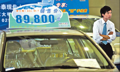 A salesperson waits for customers at a dealership in Nanjing. China's automobile sales dropped by 5.25 percent to 1.13 million units in June from May. [China Daily]