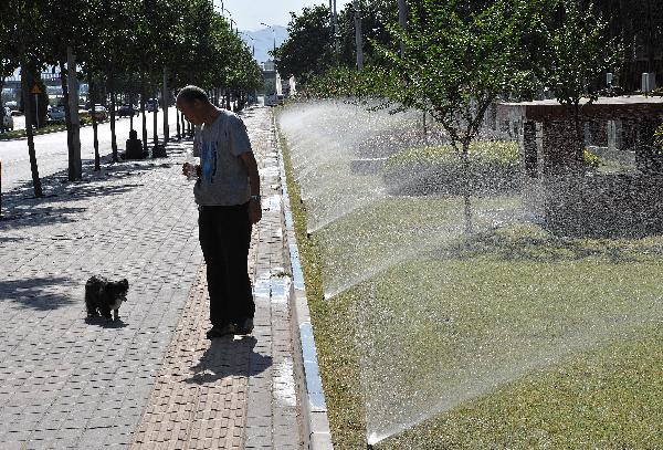An old man walks with his pet dog on street in Beijing, capital of China, July 5, 2010. Chinese meteorological authority said Monday hot weather continues to scorch many parts of the country. 