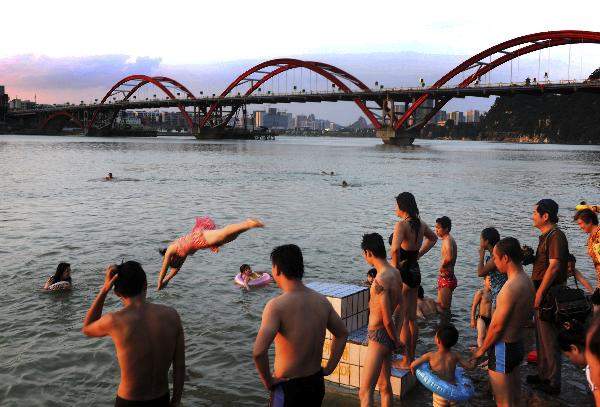 Citizens swim in the water of Liujiang River in Liuzhou, southwest China's Guangxi Zhuang Autonomous Region, July 4, 2010. Hot wave swept the Liuzhou city recently, with the highest temperature in some areas reaching 37 degrees celsius.