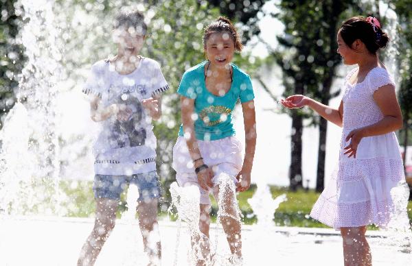 Three girls play at a fountain to enjoy coolness at the Tianjin University in north China's Tianjin Municipality, July 5, 2010. The local meteorologic authority has issued an orange alarm against high temperature.