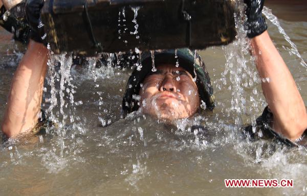 A Chinese soldier lifts a weight in the water during a Chinese-Pakistani joint anti-terrorism drill, code-named 'Friendship-2010,' in Qingtongxia of northwest China's Ningxia Hui Autonomous Region July 5, 2010. 