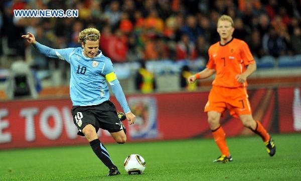 Diego Forlan (L) of Uruguay shoots during the 2010 World Cup semi-final soccer match against the Netherlands in Cape Town, South Africa, on July 6, 2010. [Xinhua] 