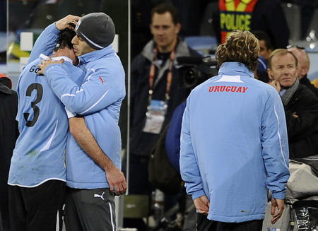 Uruguay&apos;s Luis Suarez (2nd L) consoles Diego Godin (L) next to Diego Forlan after the 2010 World Cup semi-final soccer match between Uruguay and Netherlands at Green Point stadium in Cape Town July 6, 2010. [China Daily/Agencies]