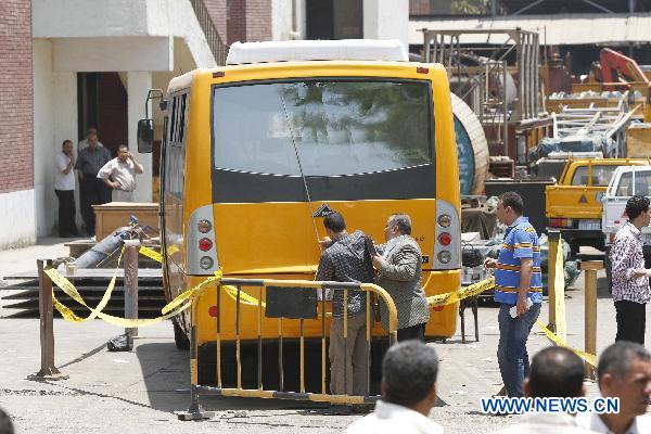 Policemen inspect the bus at the shooting site, in Hawamdia in October 6 City, 20 km south to Giza, Egypt, 6 July 2010. [Nasser Nouri/Xinhua]