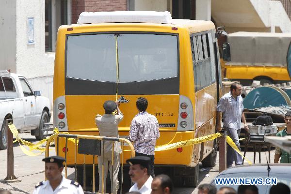 Policemen inspect the bus at the shooting site, in Hawamdia in October 6 City, 20 km south to Giza, Egypt, 6 July 2010. [Nasser Nouri/Xinhua]