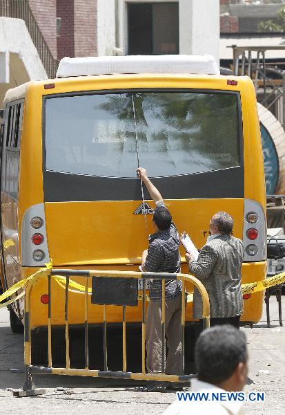 Policemen inspect the bus at the shooting site, in Hawamdia in October 6 City, 20 km south to Giza, Egypt, 6 July 2010. [Nasser Nouri/Xinhua]