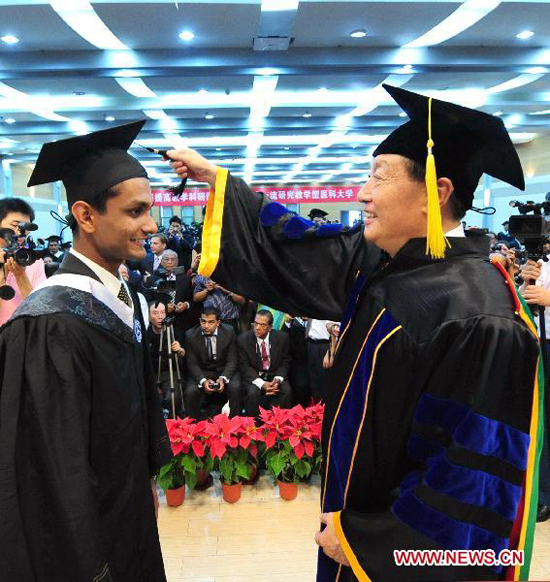 Hao Xishan (R), president of Tianjin Medical University, awards degree to a foreign student during a graduation at Tianjin Medical University in in north China's Tianjin Municipality, on July 6, 2010. More than 340 foreign students graduated from Tianjin Medical University Tuesday.