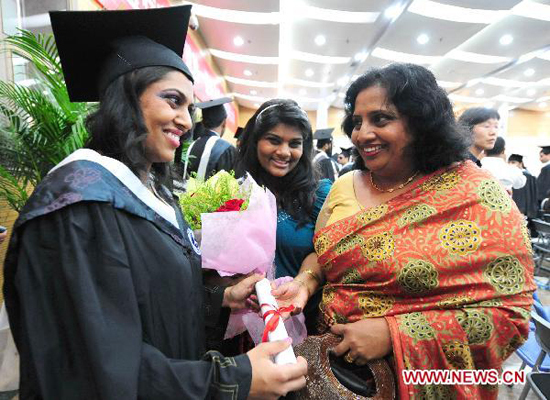 A student from Sri Lanka (L) presents her degree to her mother during a graduation at Tianjin Medical University in in north China's Tianjin Municipality, July 6, 2010. More than 340 foreign students graduated from Tianjin Medical University Tuesday.