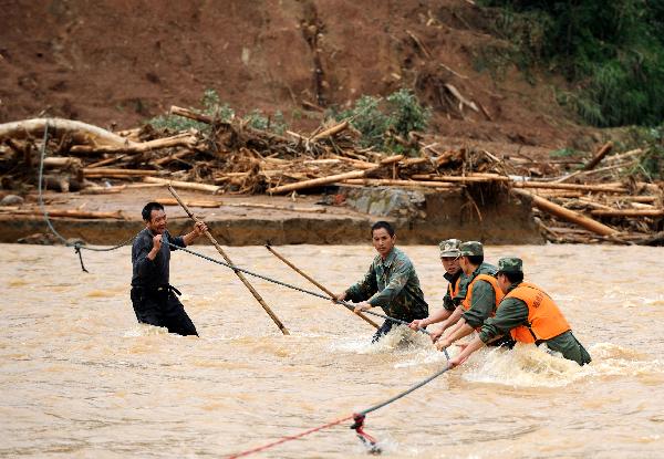 Villagers help rescuers to cross river in Shunchang, a county of southeast China's Fujian Province, June 26, 2010. More than 4 million residents of Fujian Province were affected by flood which caused 78 dead and 79 missing till June 27.[Xinhua] 
